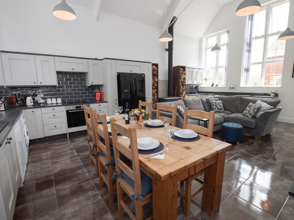 A kitchen and dining area with a table and seating at The Old School House 