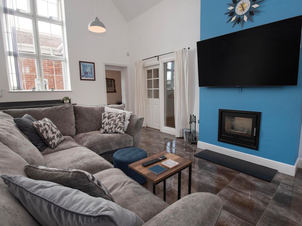 A living room with a sofa, coffee table, and fireplace at The Old School House 