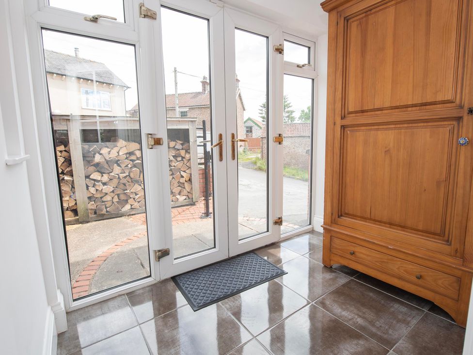 A hallway with wooden cabinet and entrance doors at The Old School House 