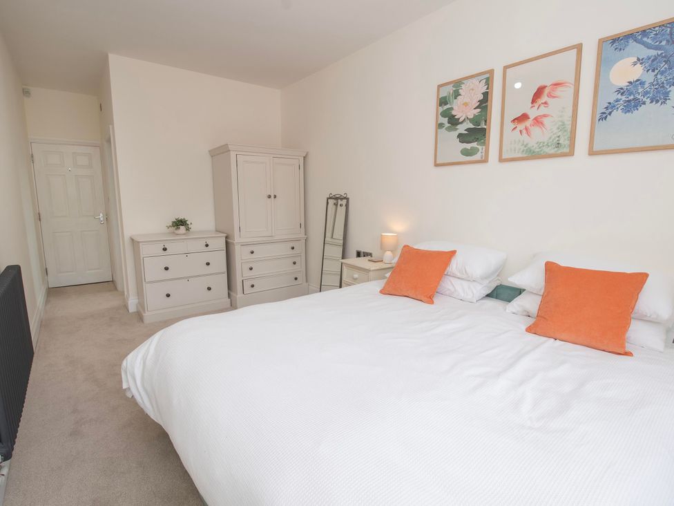 A bedroom with a bed, dresser and mirror at The Old School House