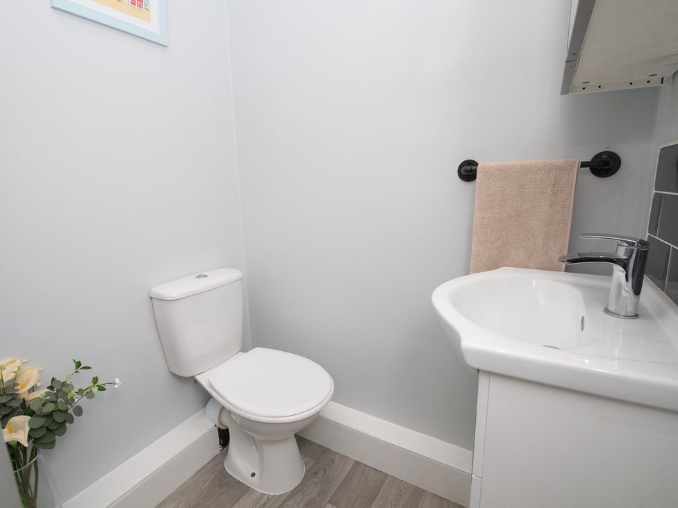 A bathroom featuring a toilet, sink, and hand towel at The Old School House 