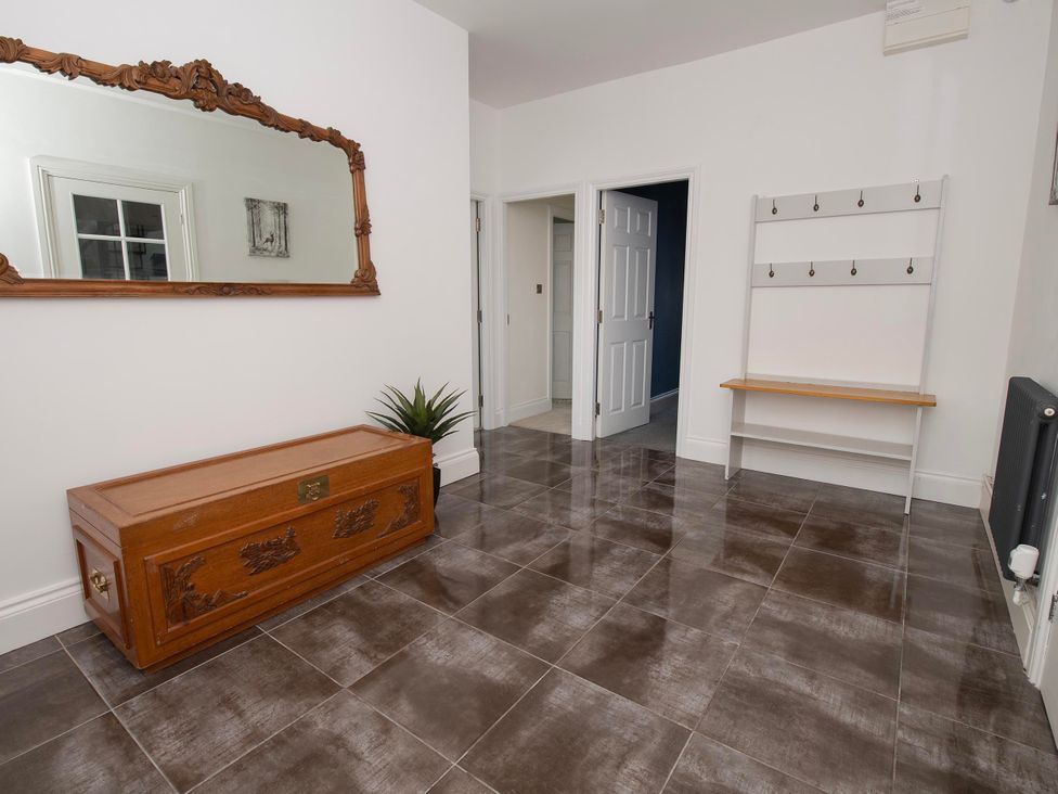 An entrance hall with a wooden bench and coat rack at The Old School House