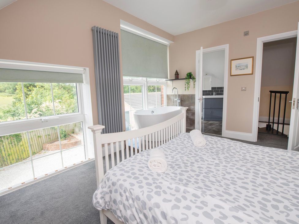 A bedroom with a bed and a bathtub at The Old School House 