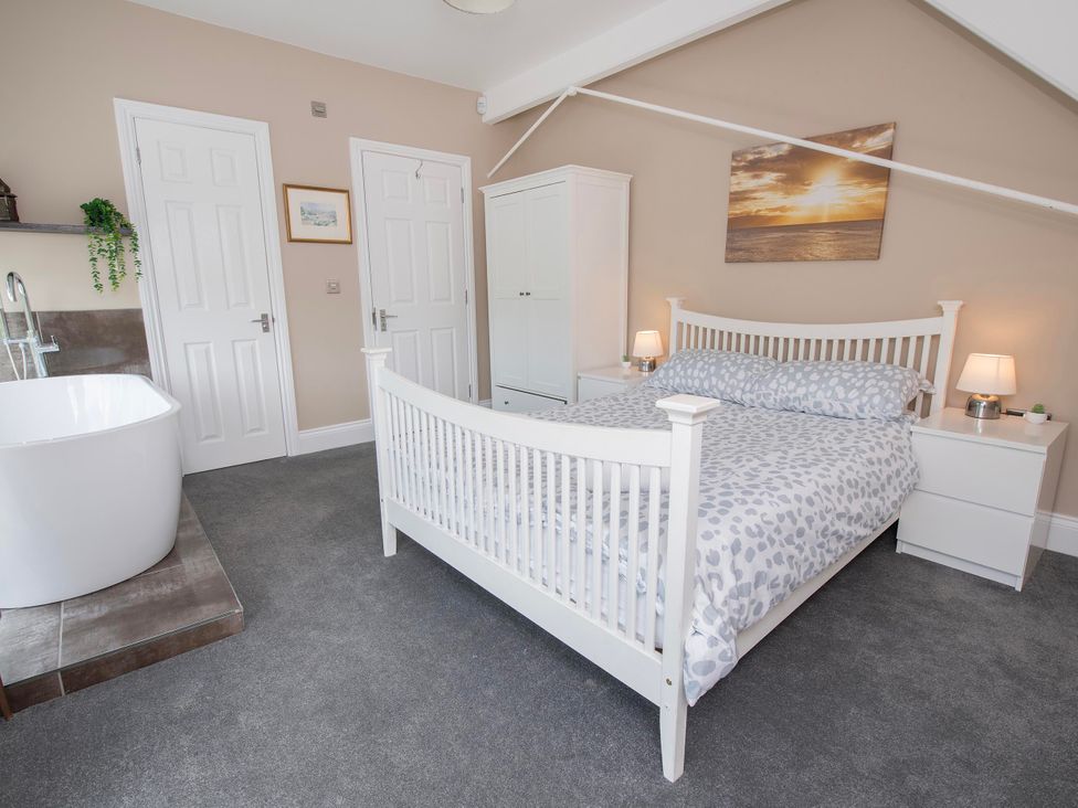 A bedroom with a bed and bathtub at The Old School House