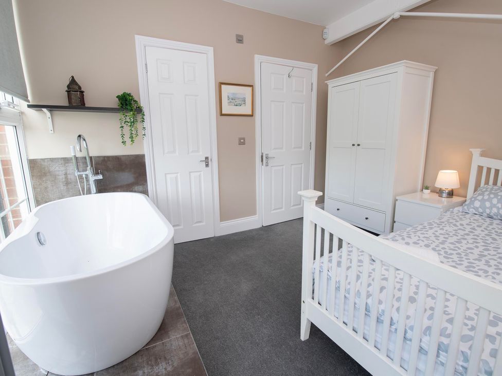 A bedroom with a bathtub and bed at The Old School House in 