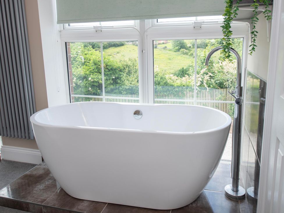 A bathroom with a bathtub and a window at The Old School House in 