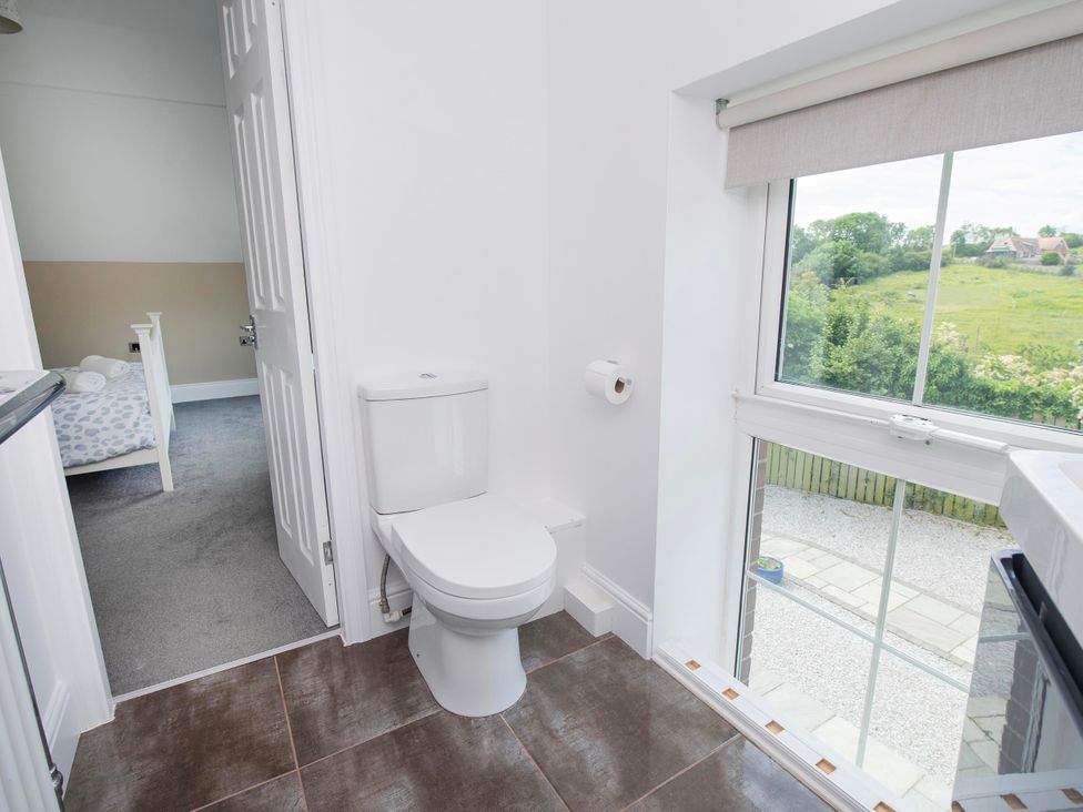 A bathroom with a toilet and window at The Old School House 