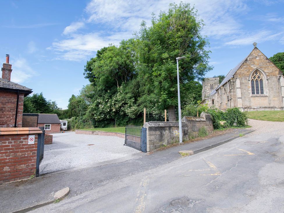 An outdoor view of a church and house with a gravel driveway at The Old School House 