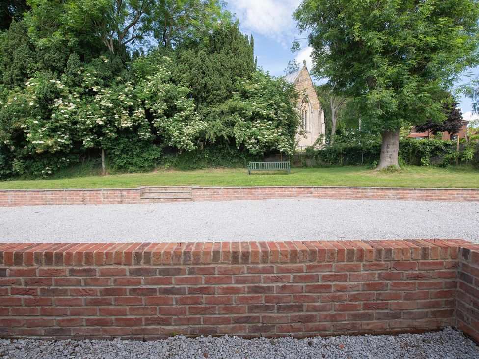 A garden with a gravel area and a bench at The Old School House in 
