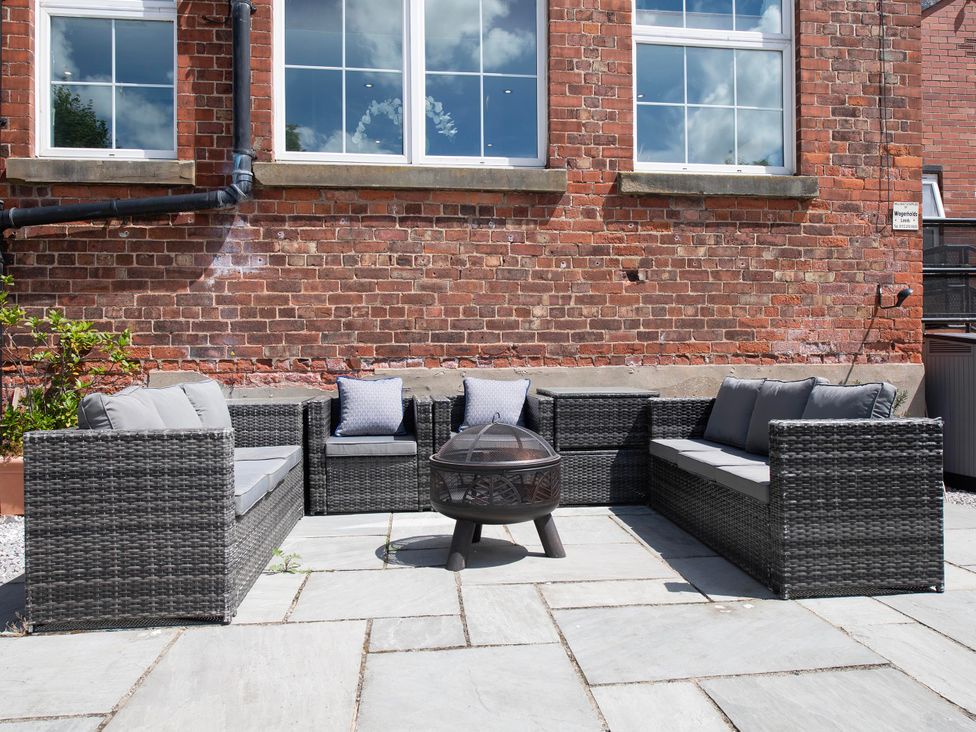 An outdoor patio with seating and a coffee table at The Old School House