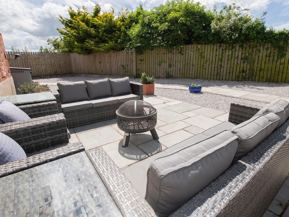 An outdoor seating area with sofas and a fire pit at The Old School House
