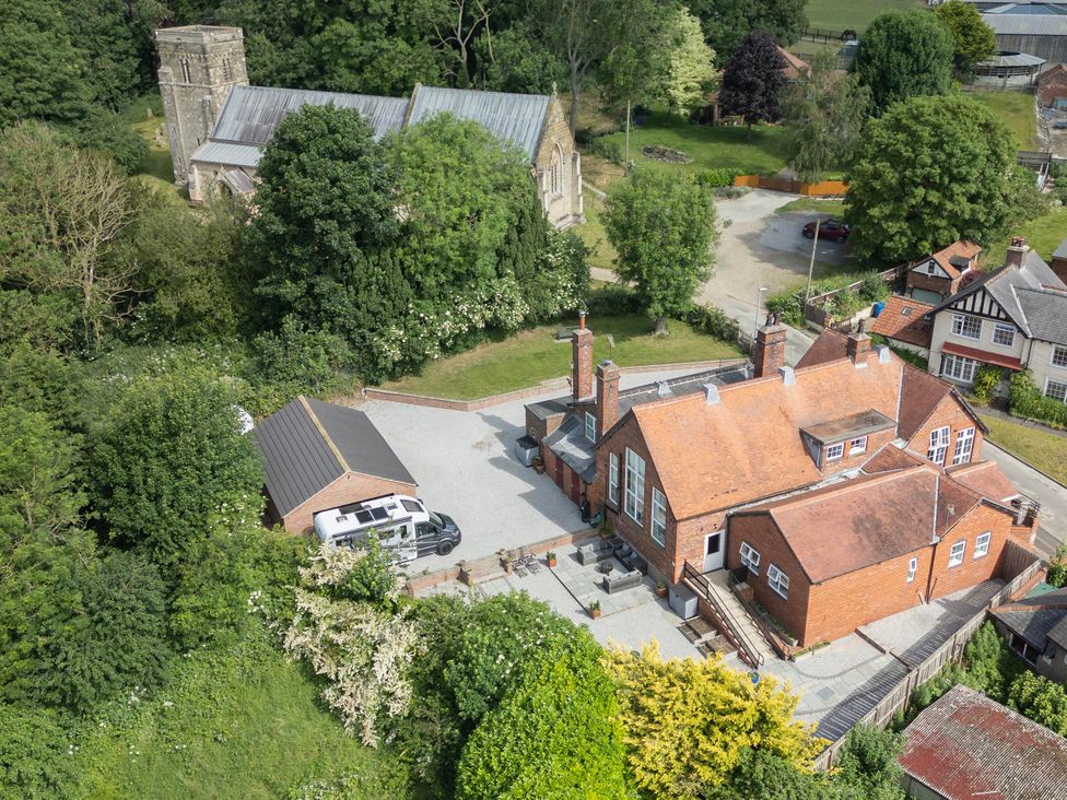 An aerial view of a house and garage surrounded by trees at The Old School House