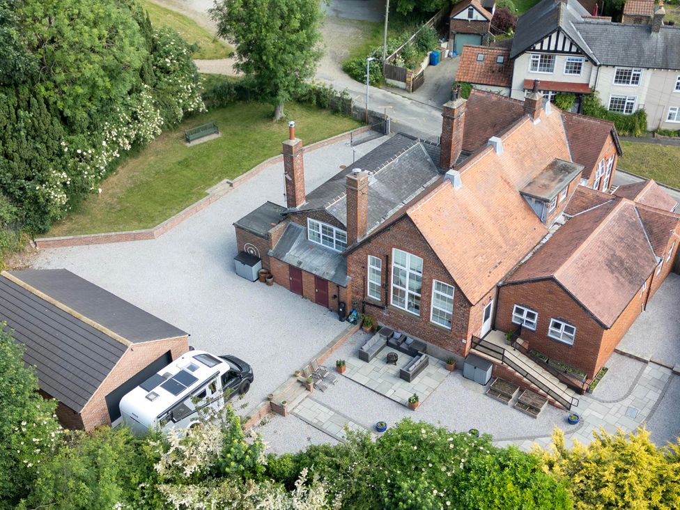 An outdoor view of a property with a garage and seating area at The Old School House