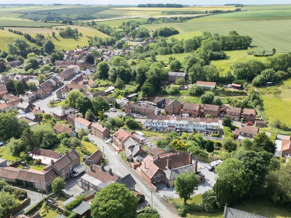 An aerial view of a village with houses and fields at The Old School House