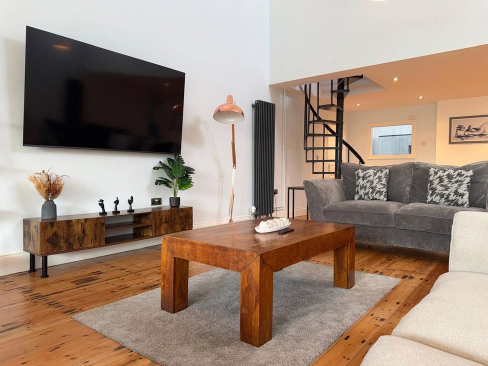 A living room with a television and coffee table at The Old School House in Langtoft