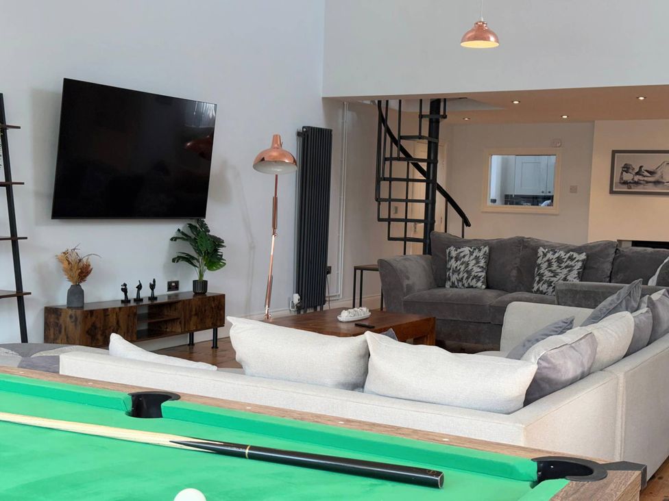 A living room with a pool table and television at The Old School House in Langtoft