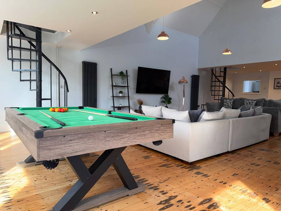 A living room with a pool table and couch at The Old School House in Langtoft