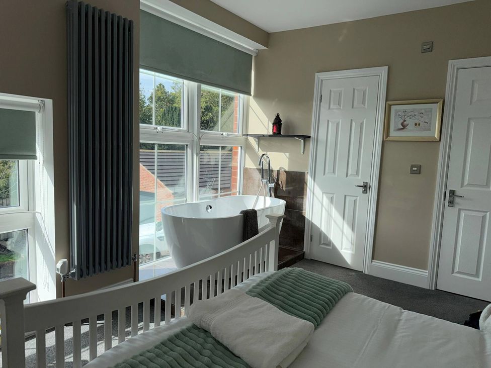 A bedroom with a bathtub and a bed at The Old School House Langtoft