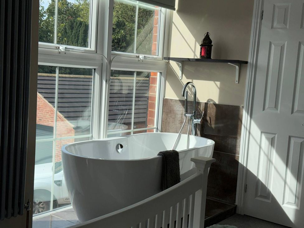 A bathroom with a bathtub and windows at The Old School House in Langtoft