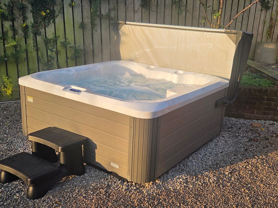 A hot tub with water in a garden at The Old School House in Langtoft
