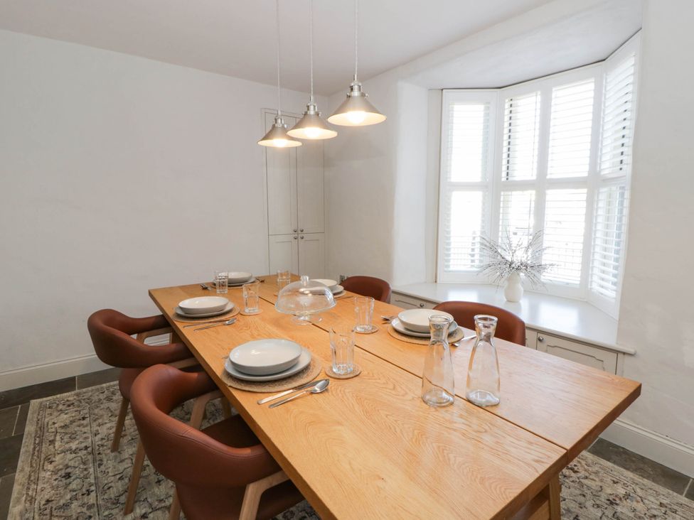 A dining room with a wooden table and chairs at Rheidiol St Davids