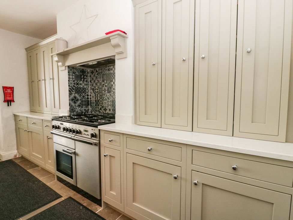 A kitchen with fitted cabinets and a stove at Rheidiol, St Davids