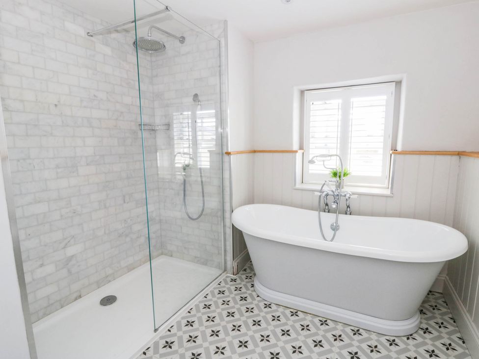 A bathroom with a shower and bathtub at Rheidiol in St Davids