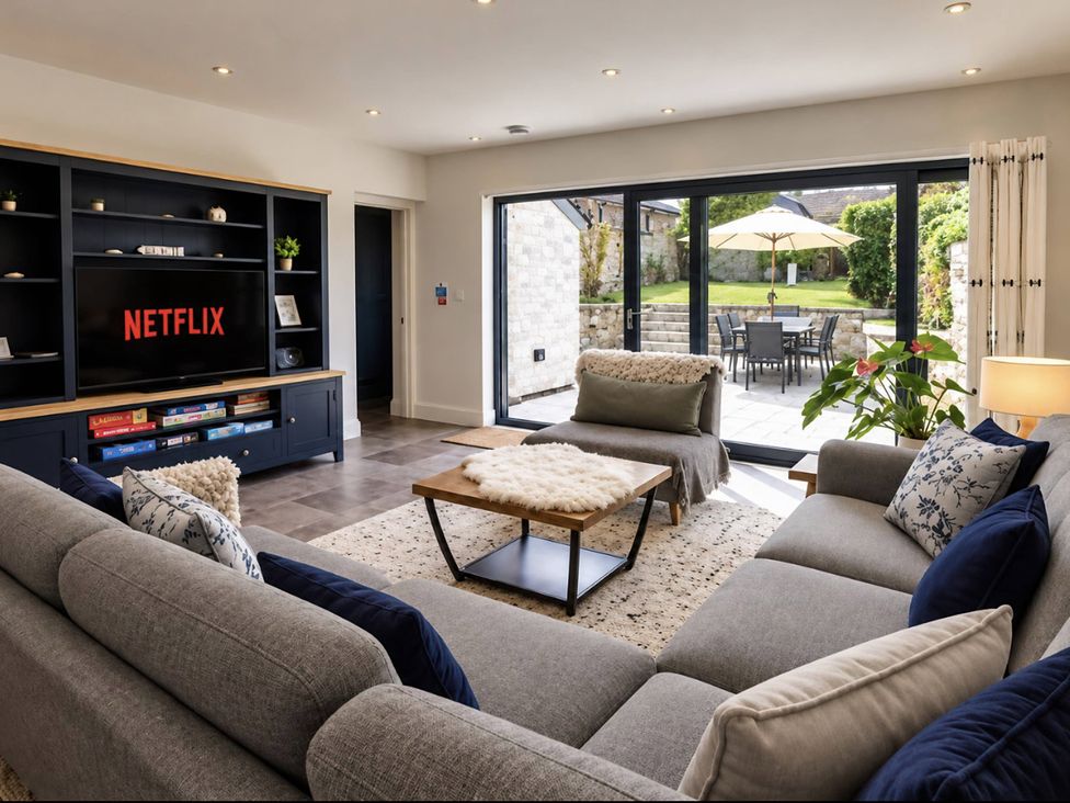 A living room with a television and sofa at Rheidiol in St Davids