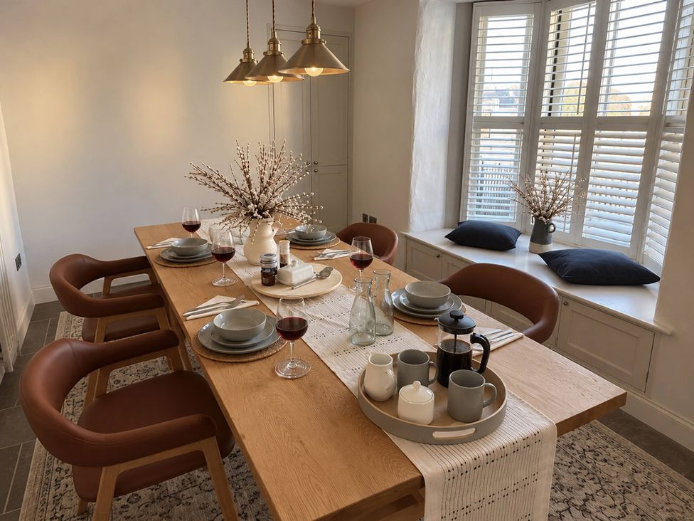 A dining room with a large table set for a meal at Rheidiol in St Davids