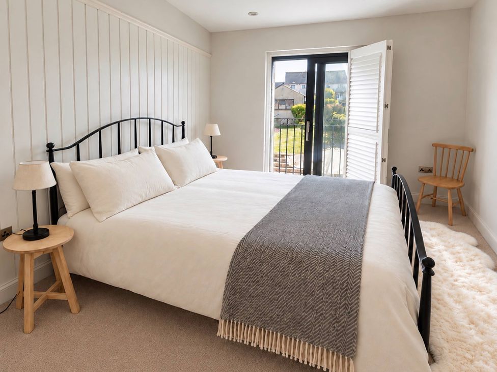 A bedroom with a bed and two bedside tables at Rheidiol in St Davids
