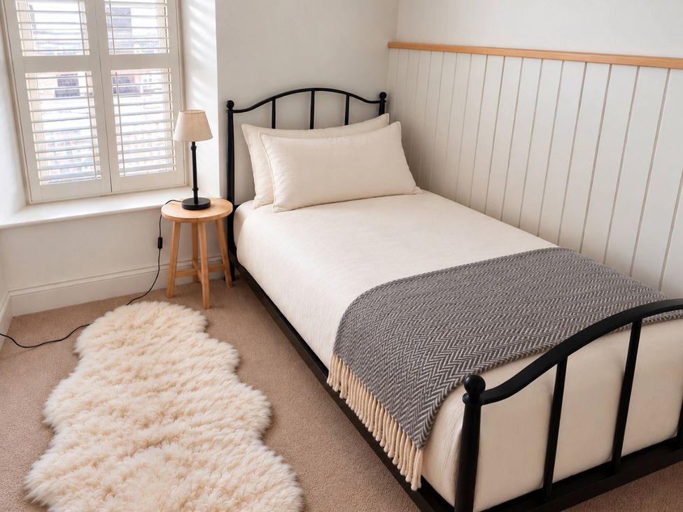 A bedroom with a bed and side table at Rheidiol in St Davids