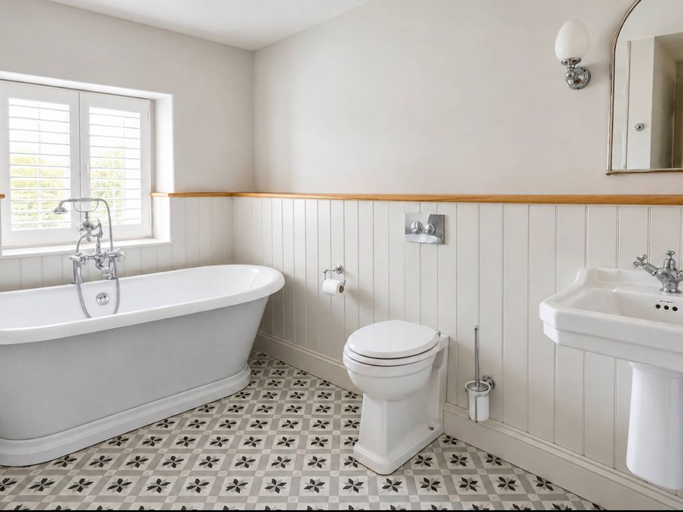 A bathroom with a bathtub, toilet, and sink at Rheidiol in St Davids