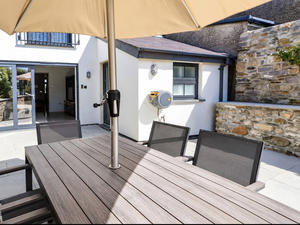 An outdoor dining area with a table and chairs at Rheidiol in St Davids
