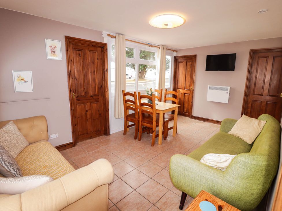 A living room with a table and chairs at Chalet 242 Carmarthen Bay in Kidwelly