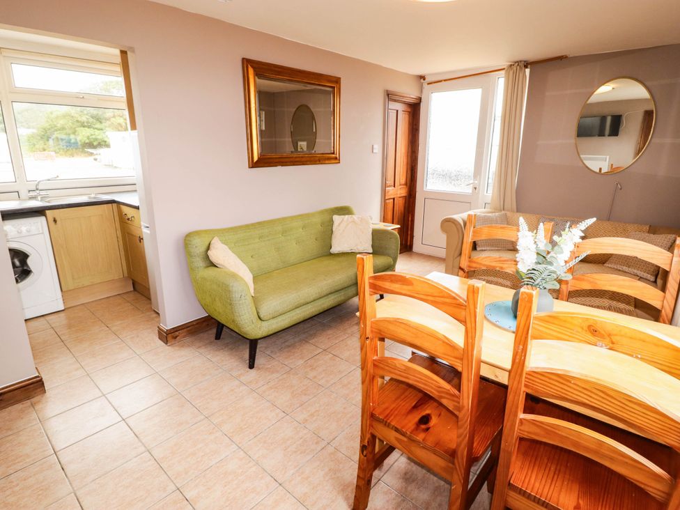 A dining room with a table and chairs at Chalet 242 Carmarthen Bay in Kidwelly