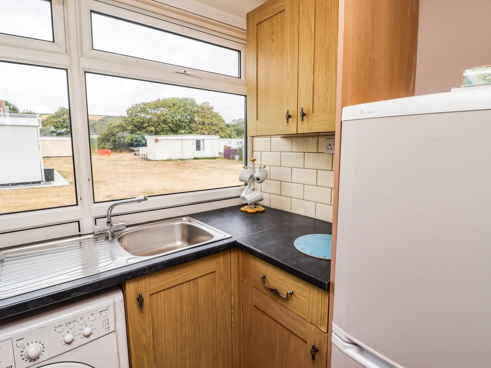 A kitchen with a sink and washing machine at Chalet 242 Carmarthen Bay in Kidwelly