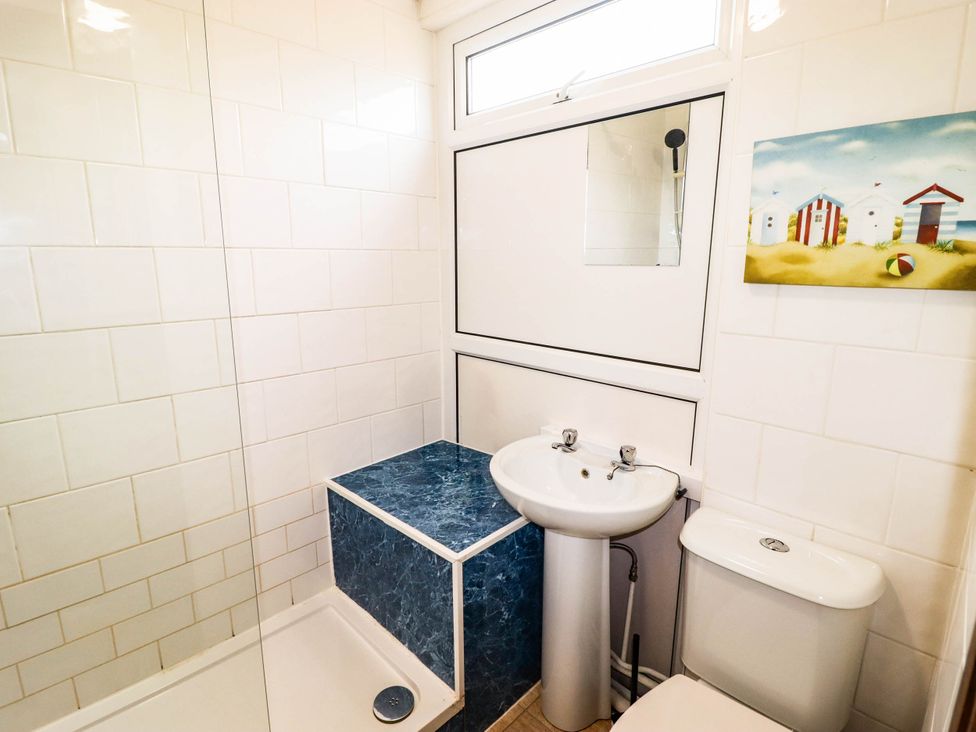 A bathroom with a shower, sink, and toilet at Chalet 242 Carmarthen Bay in Kidwelly