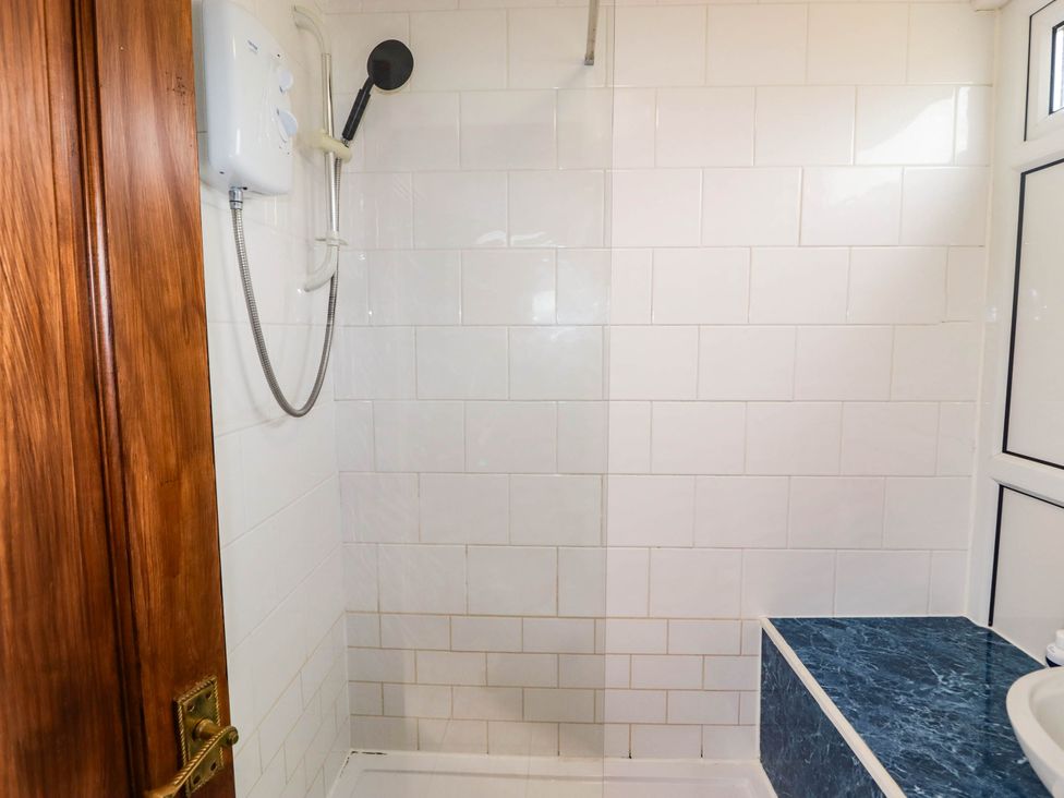 A bathroom with a shower and wash basin at Chalet 242 Carmarthen Bay, Kidwelly