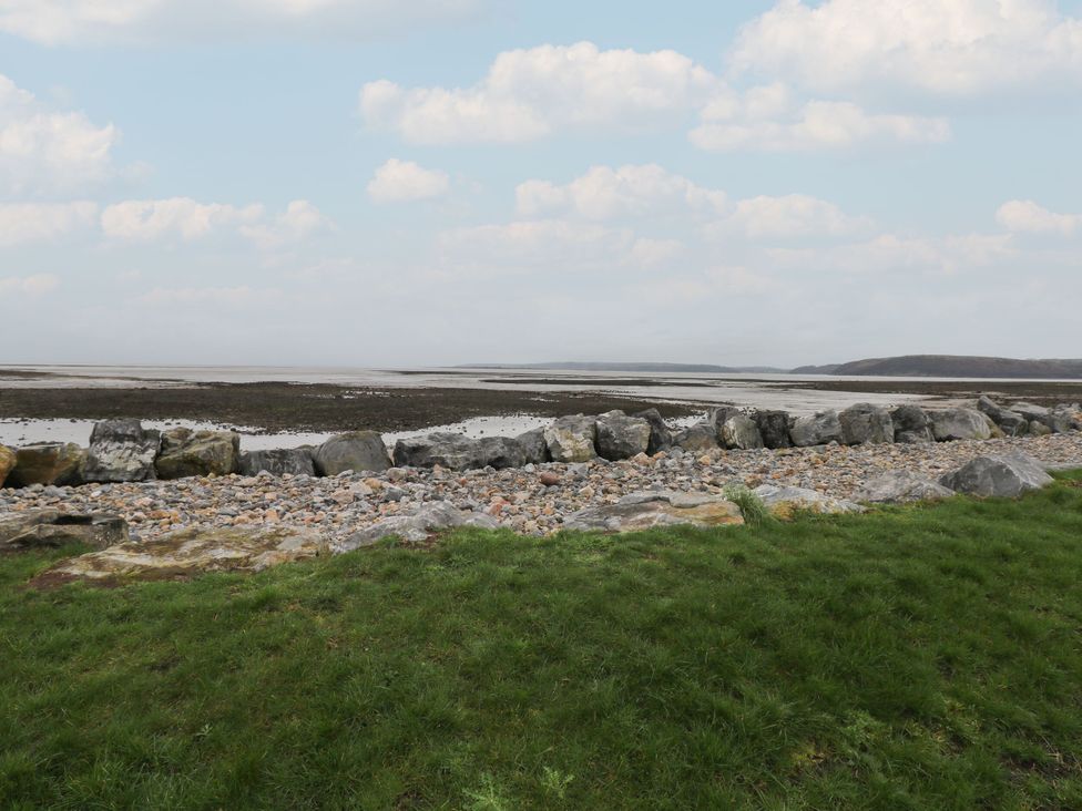 A shoreline with rocks and grass at Chalet 242 Carmarthen Bay Kidwelly