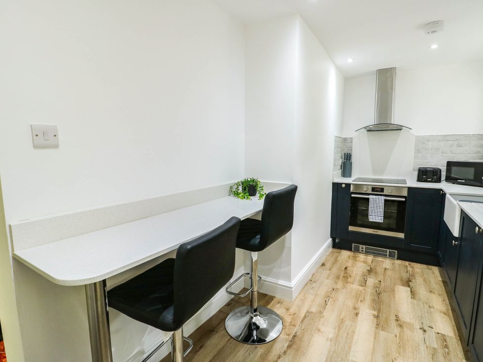 A kitchen with a bar counter and stools at River View in Betws-y-Coed