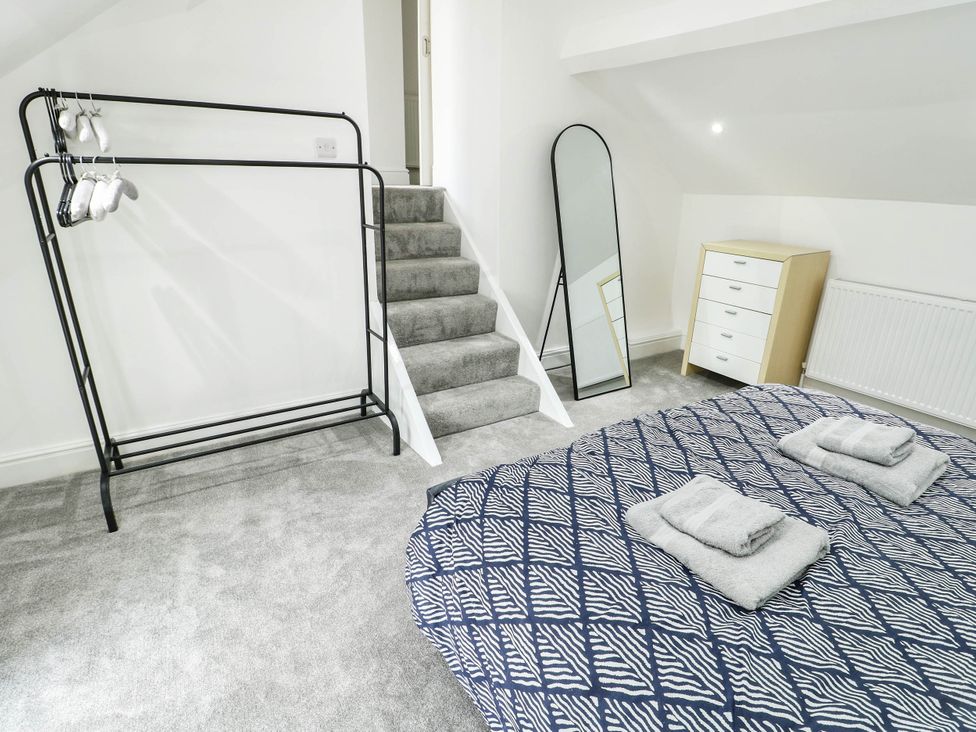 A bedroom with a bed and a mirror at River View in Betws-y-Coed