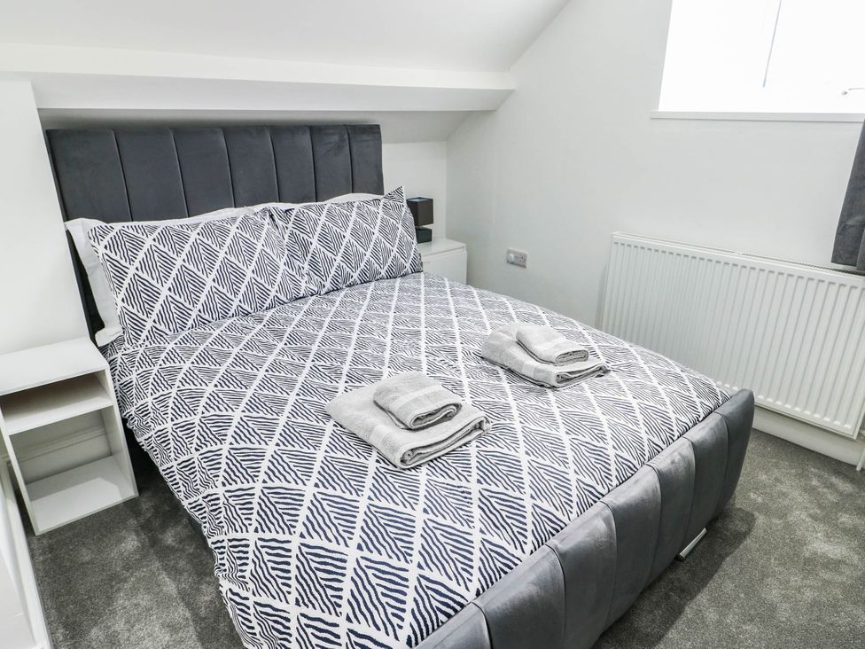 A bedroom with a bed and towels on the bed at River View in Betws-y-Coed