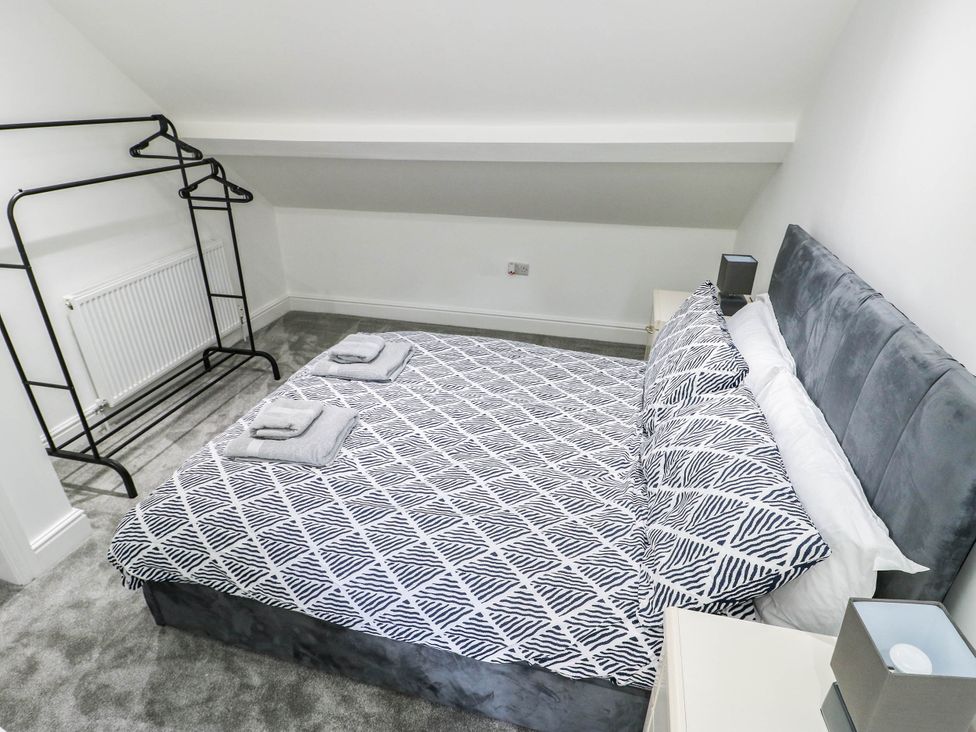 A bedroom with a bed and a clothes rack at River View in Betws-y-Coed