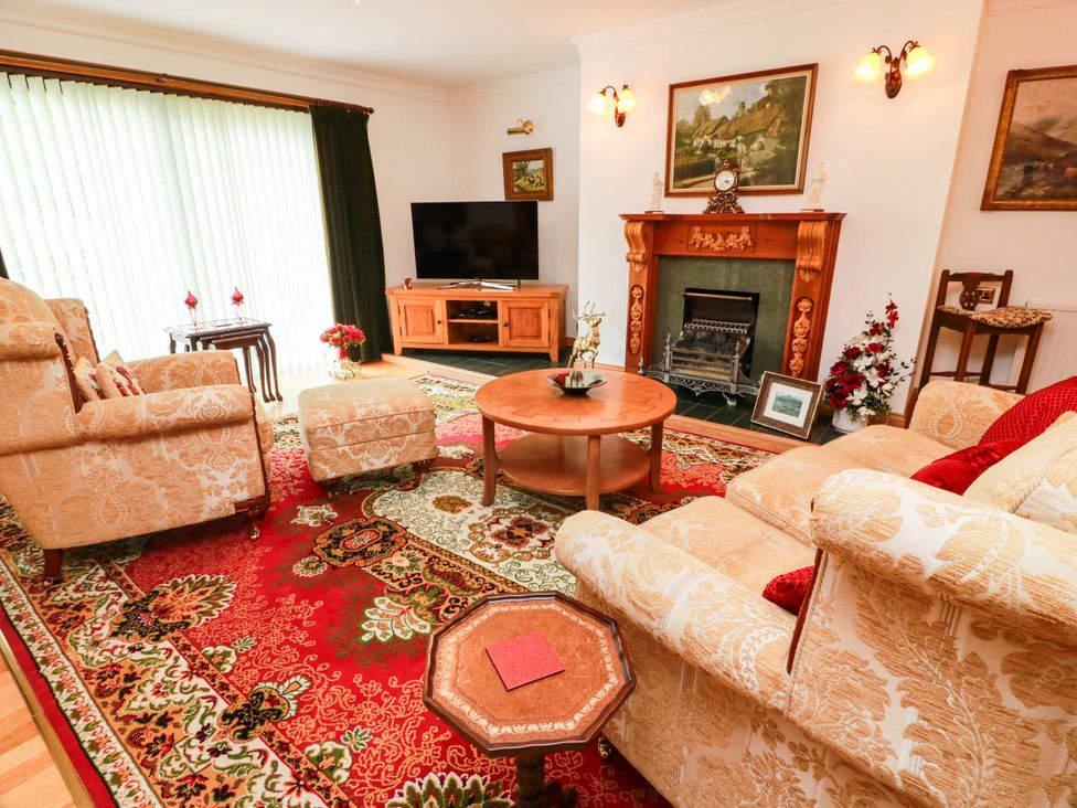 A living room with a sofa, armchair, and television at Wallvilla 