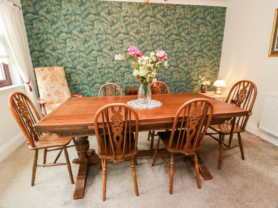 A dining room with a wooden table and chairs at Wallvilla