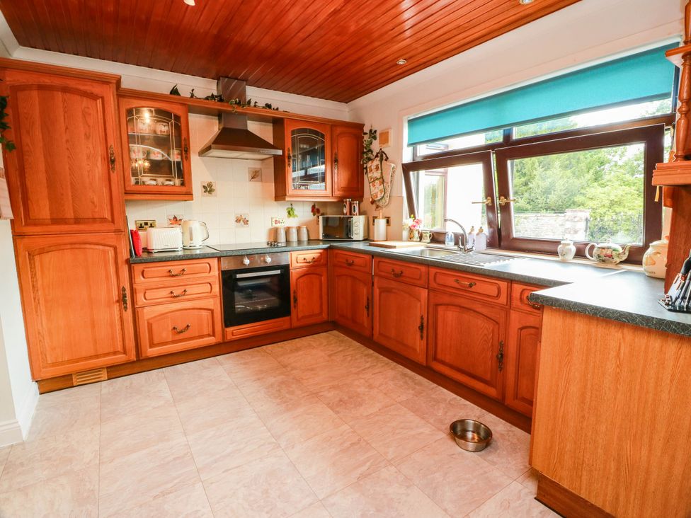 A kitchen with wooden cabinets and appliances at Wallvilla