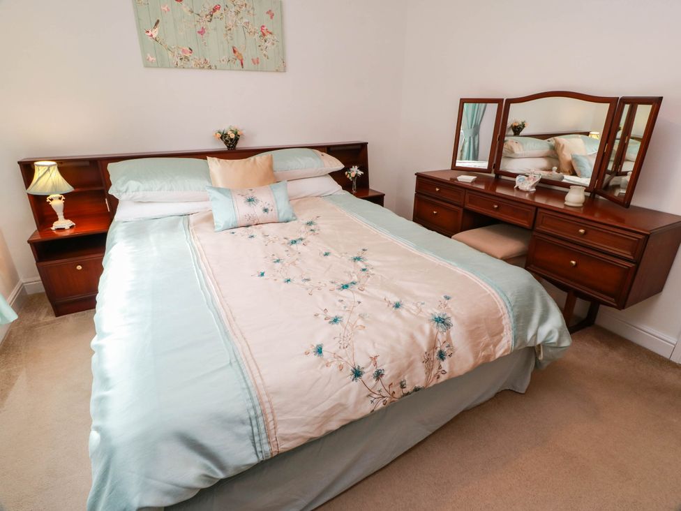 A bedroom with a bed and a dressing table at Wallvilla