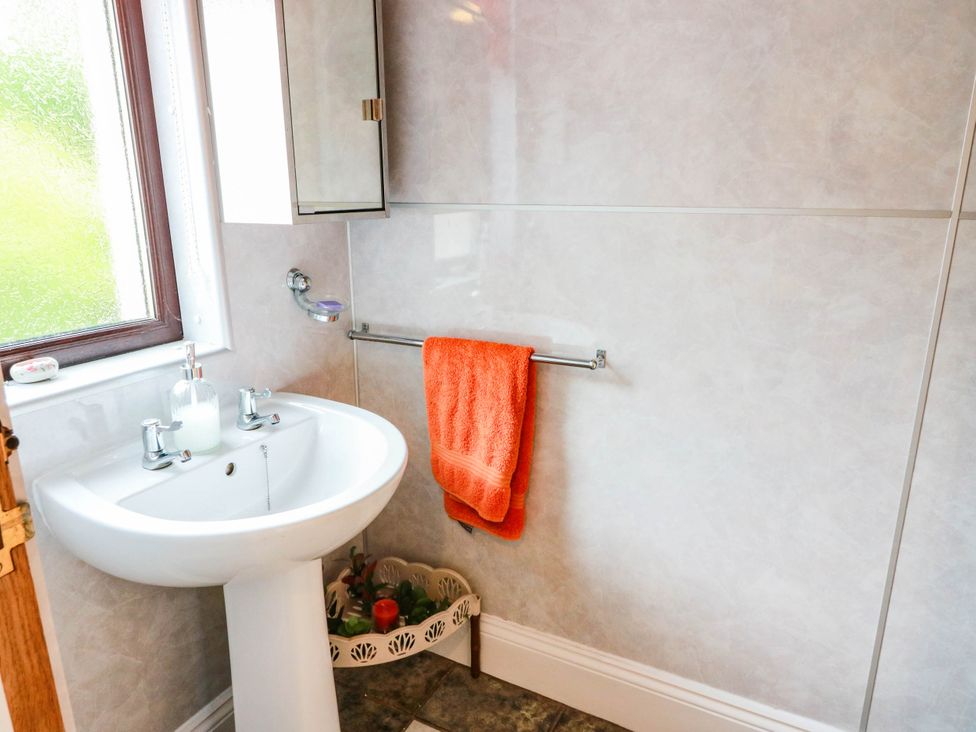 A bathroom with a sink and an orange towel at Wallvilla