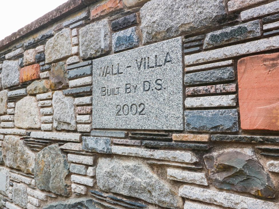 A stone wall with a plaque stating Wall-villa built by D.S. 2002 at Wallvilla