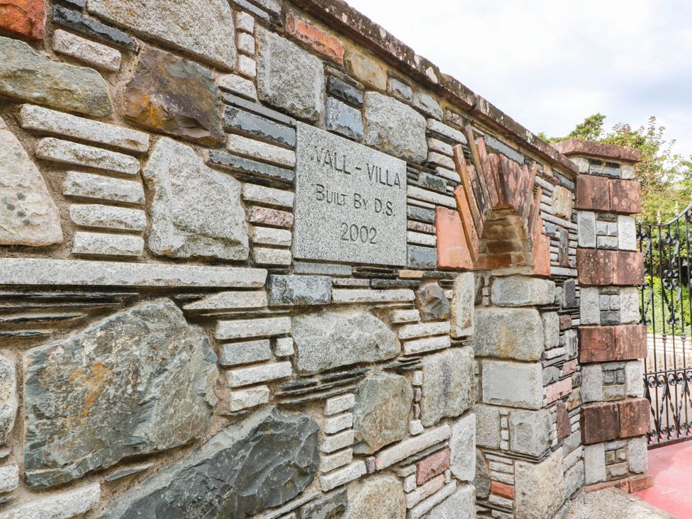 A stone wall with a plaque at Wallvilla